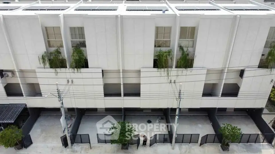 Modern townhouse exterior with sleek design and greenery accents