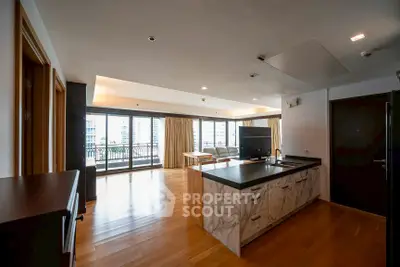 Spacious open-plan living room with modern kitchen and balcony view