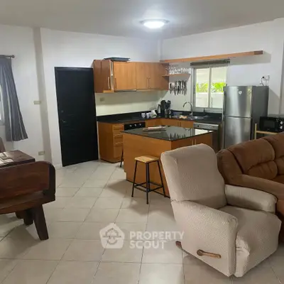 Spacious open-layout kitchen and living area with modern appliances and cozy seating.