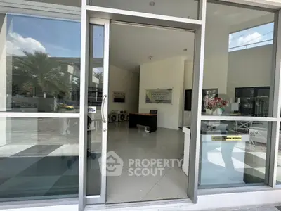 Modern office entrance with glass doors and sleek interior design.