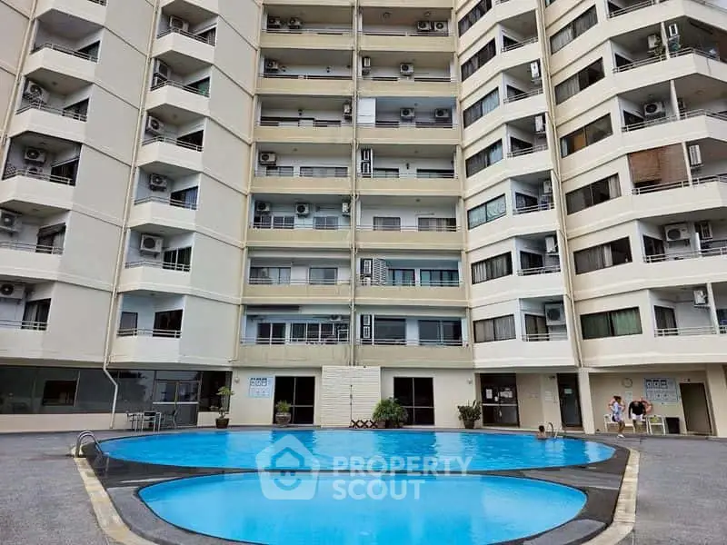 Modern apartment building with inviting pool area and spacious balconies.