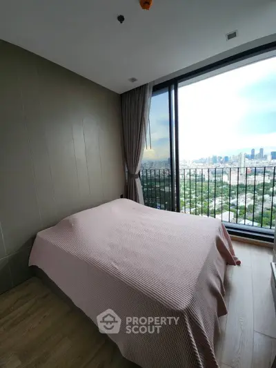 Modern bedroom with panoramic city view and large window, offering a serene and stylish living space.