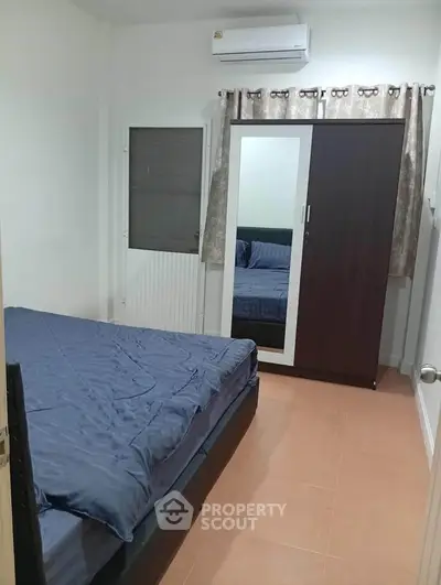 Cozy bedroom with mirrored wardrobe and air conditioning, perfect for restful nights.