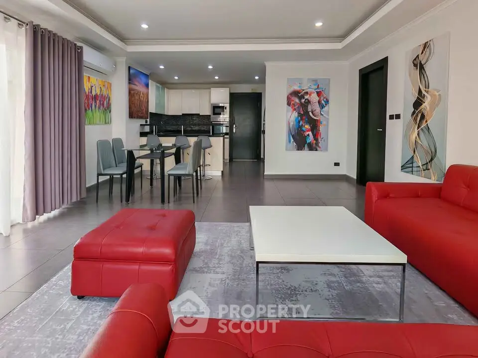 Spacious modern living room with red sofas and open kitchen layout