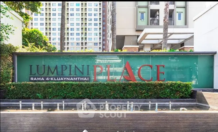 Modern condominium entrance with lush greenery and stylish signage at Lumpini Place.