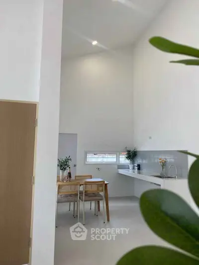 Modern minimalist kitchen with dining area and high ceiling