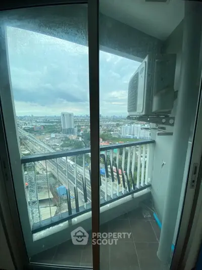 High-rise balcony with cityscape view and air conditioning unit, perfect for urban living.