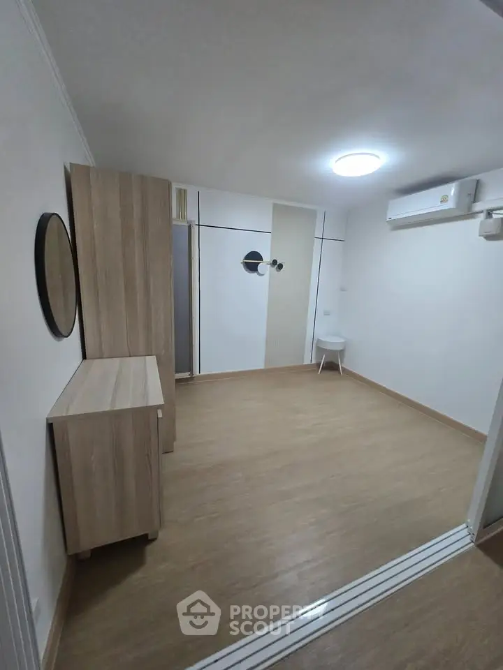Modern minimalist room with wooden flooring and sleek furniture, perfect for a cozy living space.