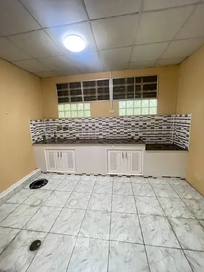 Spacious kitchen with tiled flooring and modern backsplash, ideal for culinary enthusiasts.