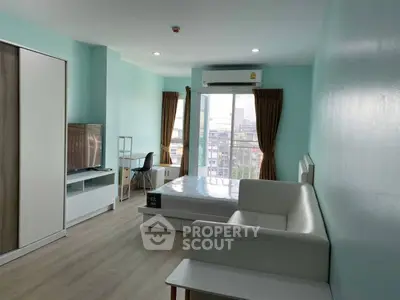 Modern studio apartment with city view, featuring sleek furniture and ample natural light.