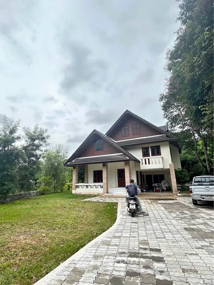 Charming countryside house with lush greenery and spacious driveway