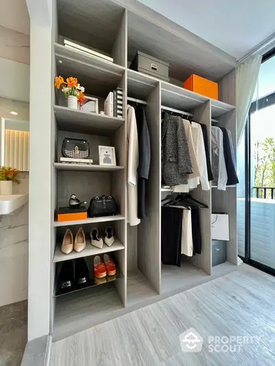 Stylish modern wardrobe with open shelving and hanging space in a bright room