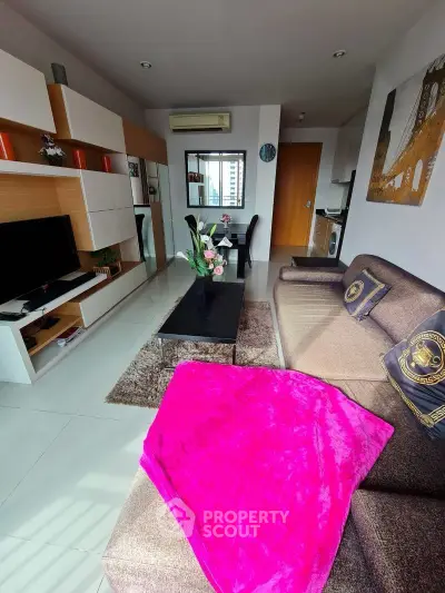 Modern living room with stylish decor, cozy sofa, and entertainment center in a bright apartment.