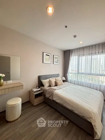 Modern bedroom with city view, stylish decor, and natural light.