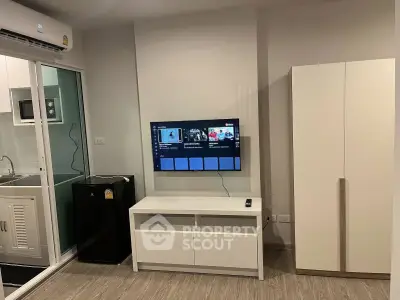 Modern living room with wall-mounted TV, air conditioning, and sleek furniture in a stylish apartment.