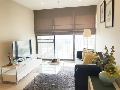 Modern living room with large windows and stylish decor in a high-rise apartment.