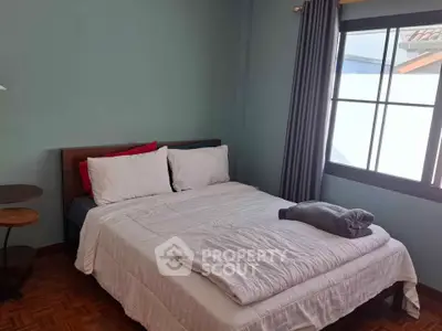 Cozy bedroom with large window and stylish decor