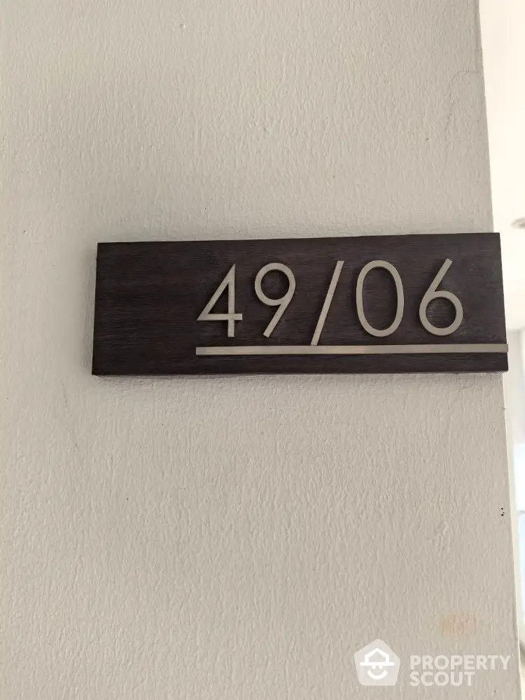 Modern apartment number sign on white wall, sleek design for contemporary living spaces.