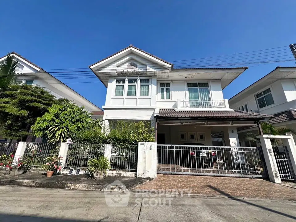 Charming two-story house with a spacious front yard and gated entrance in a serene neighborhood.