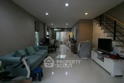 Spacious living room with modern decor and sleek staircase in a contemporary home.