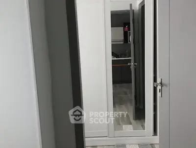 Modern interior with sleek doors and mirrored closet reflecting a stylish kitchen.
