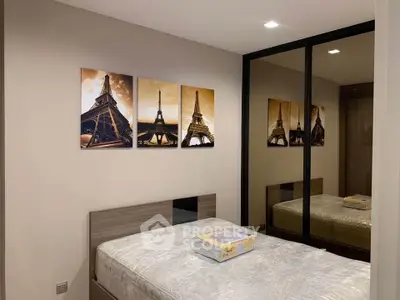 Modern bedroom with mirrored closet and stylish Eiffel Tower artwork, perfect for urban living.