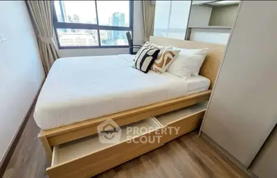 Modern bedroom with city view, featuring a stylish bed with built-in storage drawers and elegant decor.