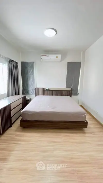 Spacious bedroom with modern design, featuring a large bed and ample natural light.