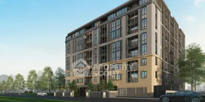 Modern apartment building with large windows and landscaped surroundings.