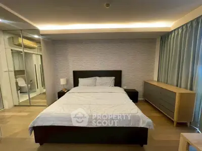 Spacious modern bedroom with elegant decor and ensuite bathroom in luxury apartment.