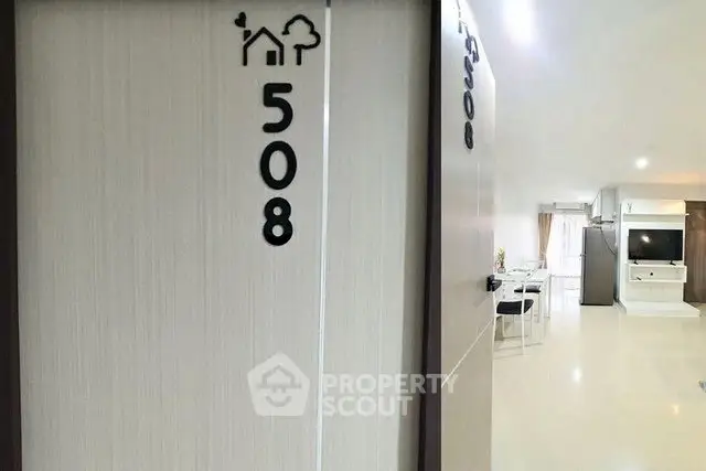 Modern apartment entrance with open view of living area and dining space.