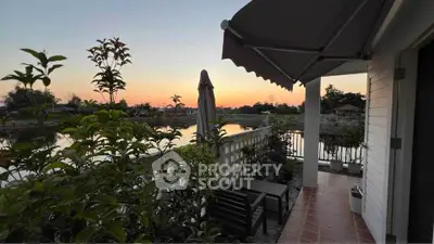 Charming balcony with sunset view overlooking serene water landscape.