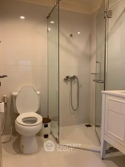 Modern bathroom with glass shower and white fixtures