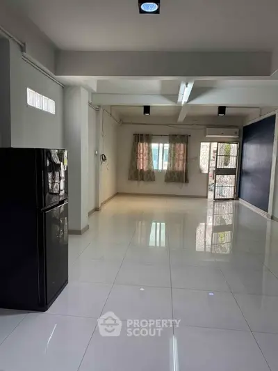 Spacious modern living area with glossy tiled floors and natural light.