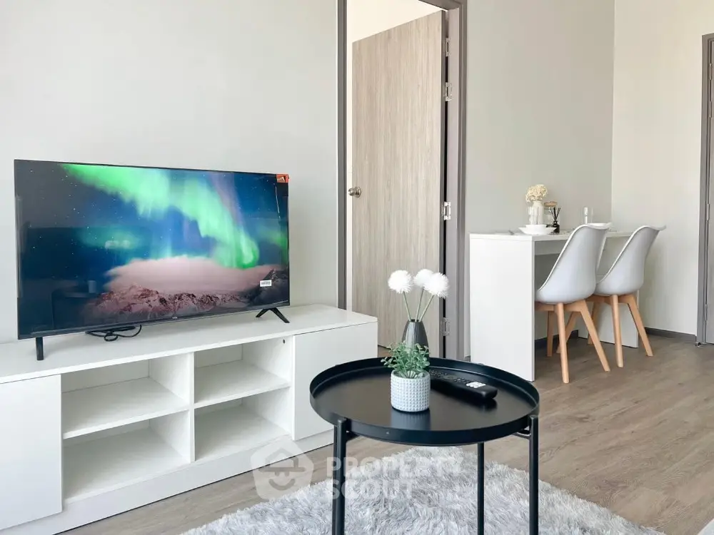 Modern living room with stylish decor and TV, open dining area, and cozy ambiance.