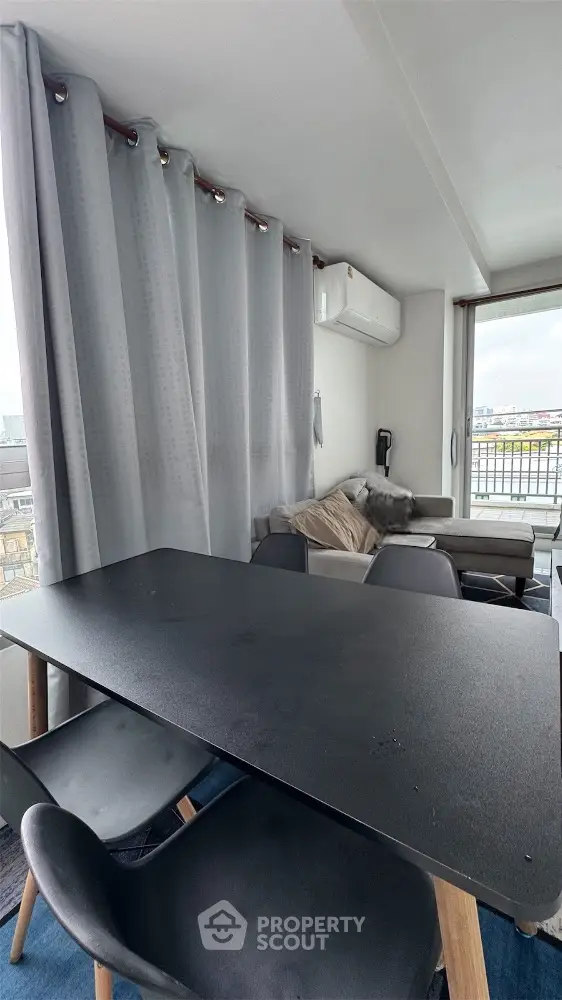 Modern living room with sleek black dining table and city view
