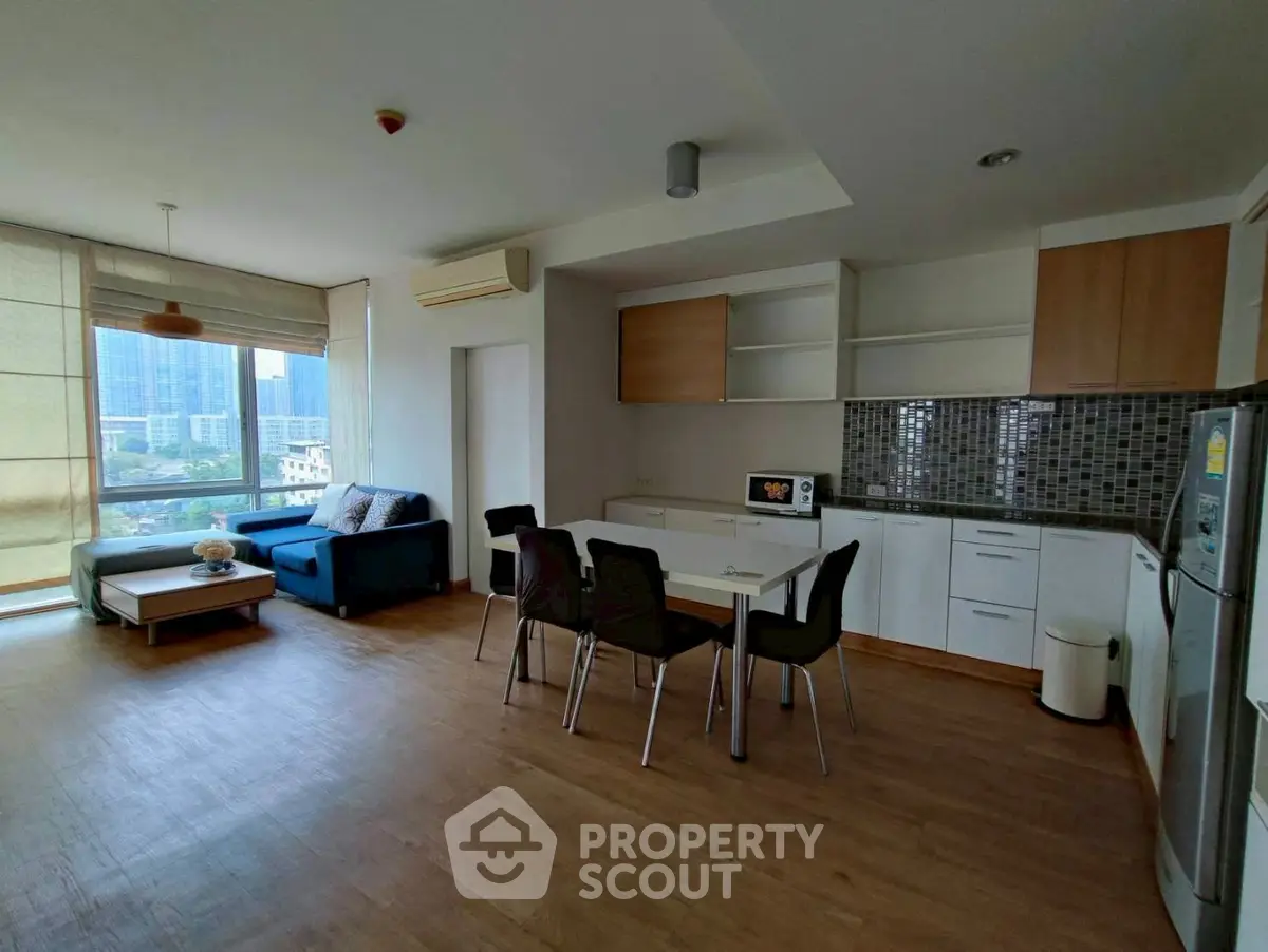 Spacious open-plan living room with modern kitchen and city view