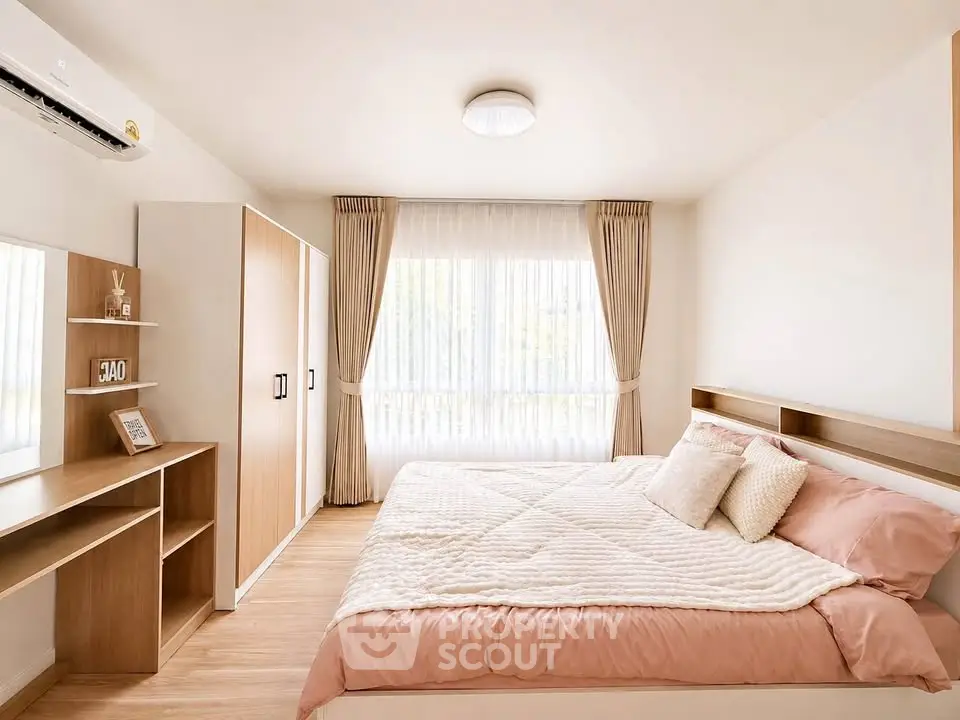 Spacious and bright bedroom with modern furnishings and large window.