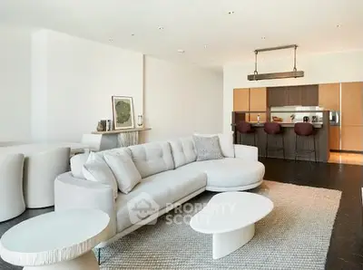 Spacious modern living room with elegant furniture and open kitchen layout.
