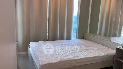 Cozy bedroom with large window and elegant curtains, perfect for relaxation.