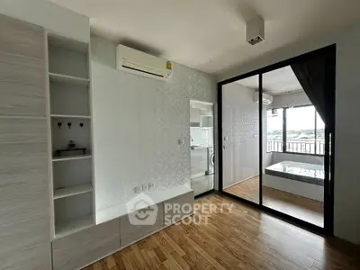 Modern bedroom with wooden flooring and balcony access in a stylish apartment
