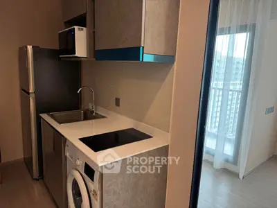 Modern compact kitchen with sleek appliances and balcony view