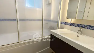 Modern bathroom with sleek vanity and glass shower enclosure