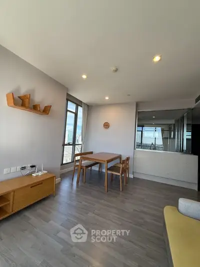 Modern living room with large windows and stylish furniture in a high-rise apartment.