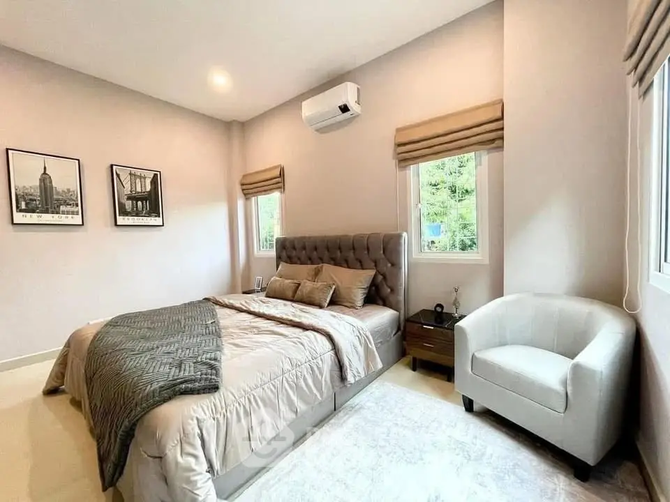 Elegant bedroom with plush bed, modern decor, and natural light, perfect for relaxation.