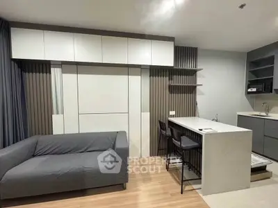 Modern living room with sleek kitchen and stylish furniture in open layout apartment.