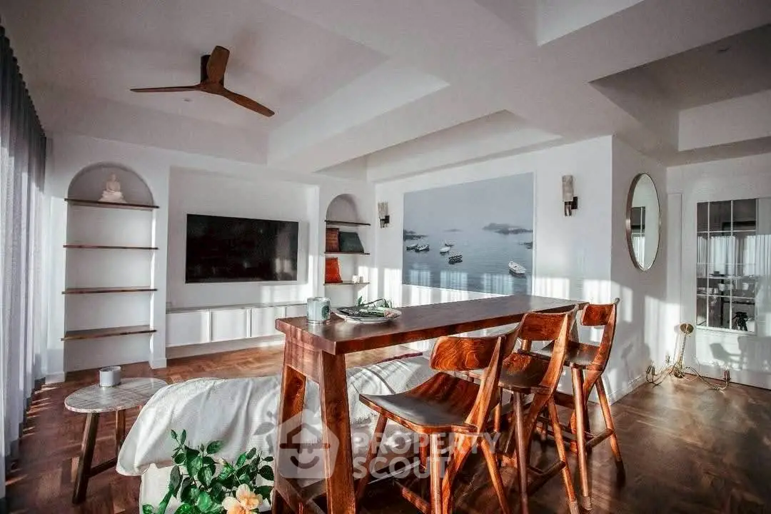 Spacious modern living room with wooden furniture and large TV, perfect for relaxation and entertainment.