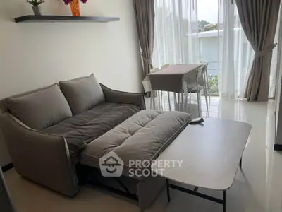 Modern living room with cozy sofa and dining area, featuring natural light and elegant decor.