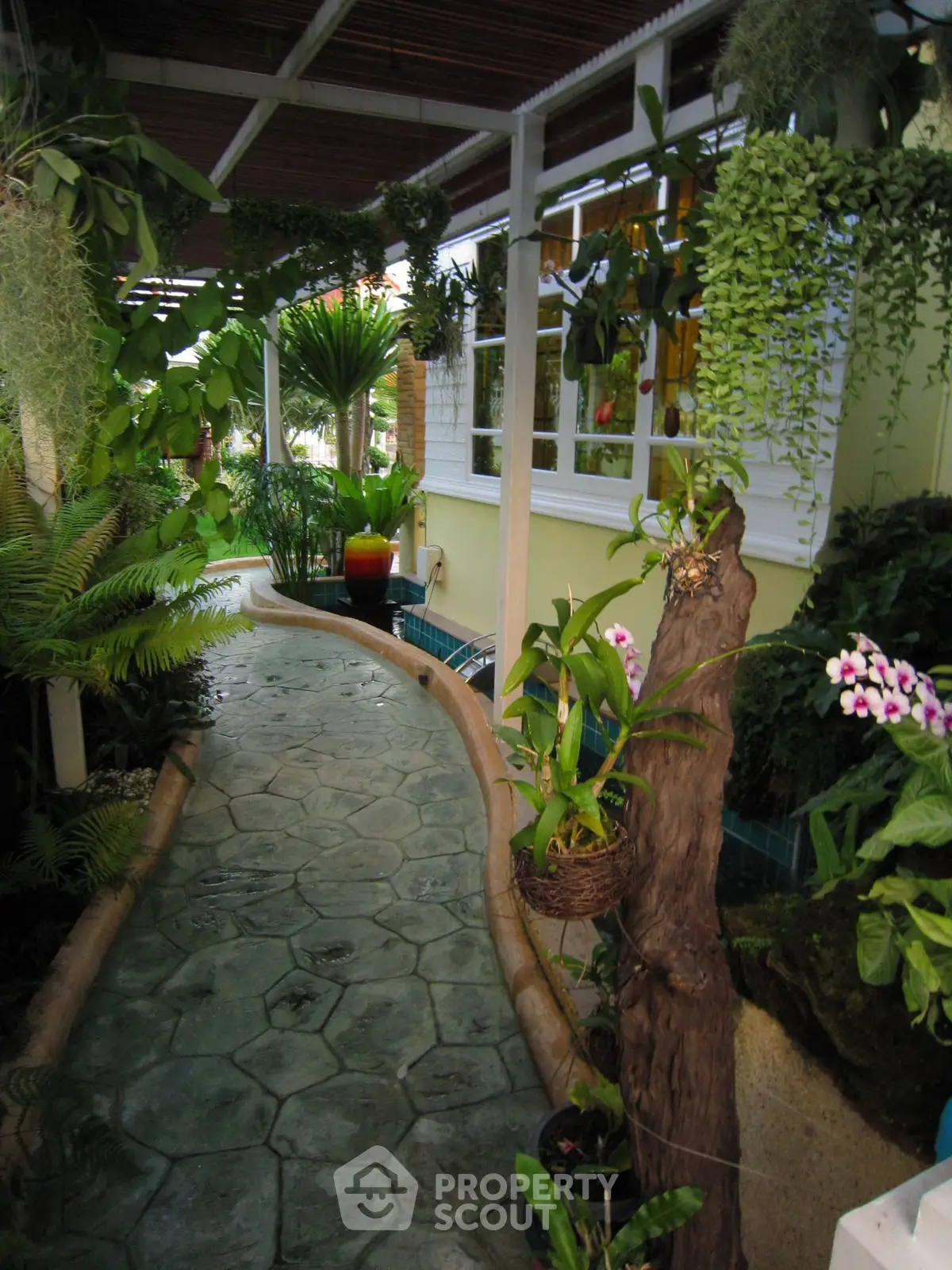 Charming garden pathway with lush greenery and decorative plants in a serene residential setting.