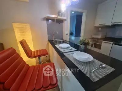 Modern kitchen with sleek black countertop and stylish red bar stools